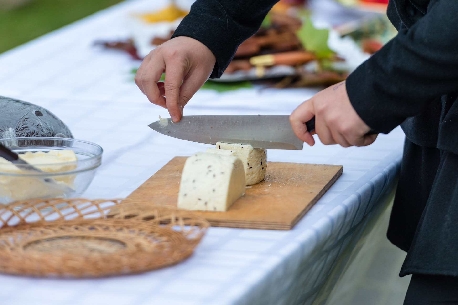 Worker slicing the cheese. Close up of hands cut with a knife c